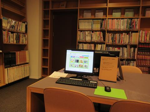 書架の前の机に、データベース端末が置いてある写真。