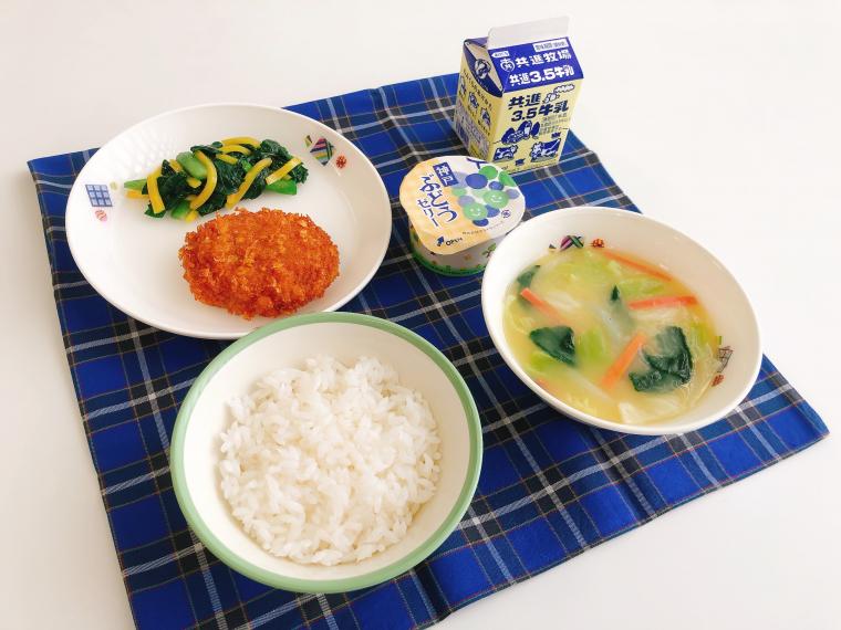こうべ特産給食の写真（米飯・神戸たまねぎミンチカツ・こまつなとたくあんのいためもの・みそしる・神戸ぶどうゼリー）